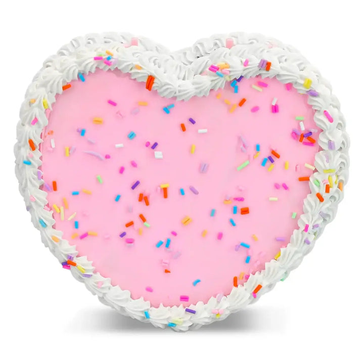 Heart-shaped pink cake with white frosting and colorful sprinkles on a white background