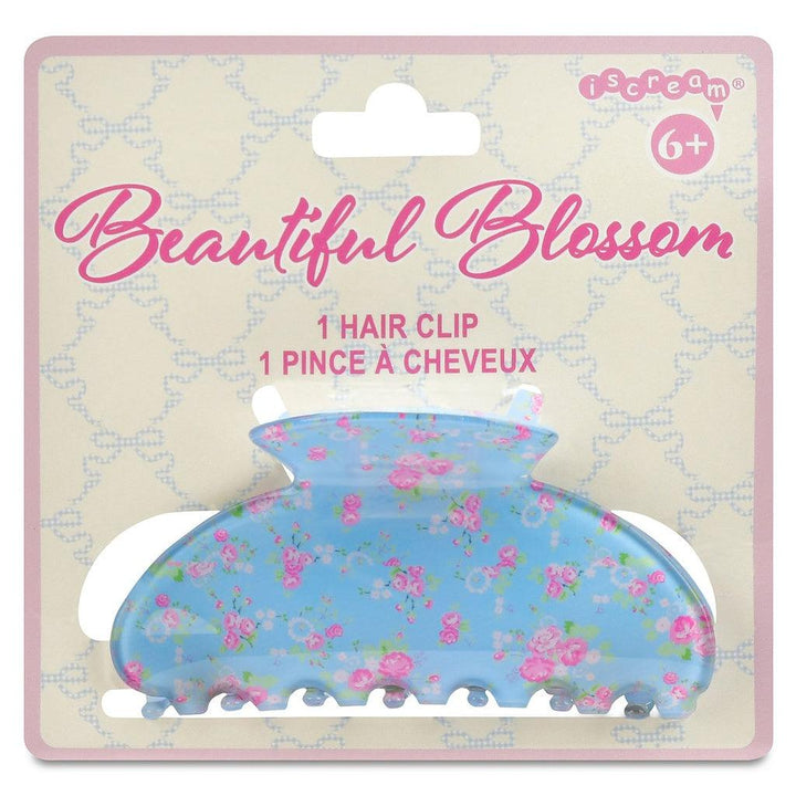 blue claw clip with tiny pink florals all over the clip. attached to a branded card