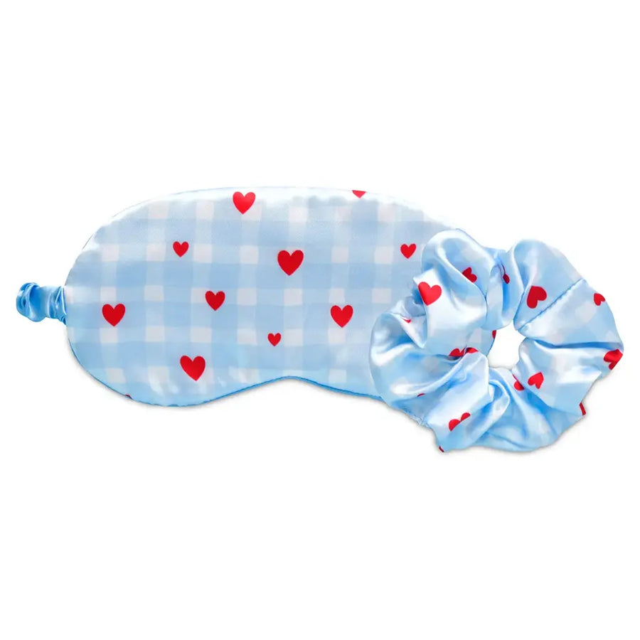 Blue sleep mask with red heart patterns on a white background