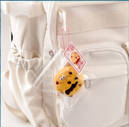 Plush charm attached to a white bag with a pink tag