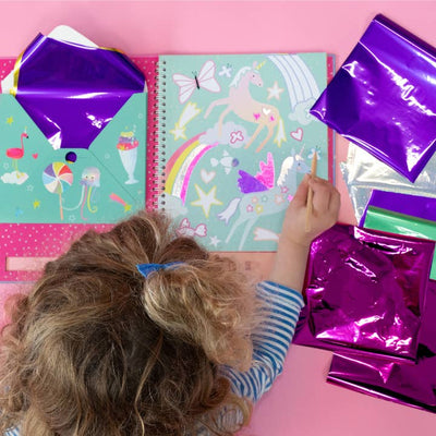 young girl showing how to use the foil in the book to accent pictures. 