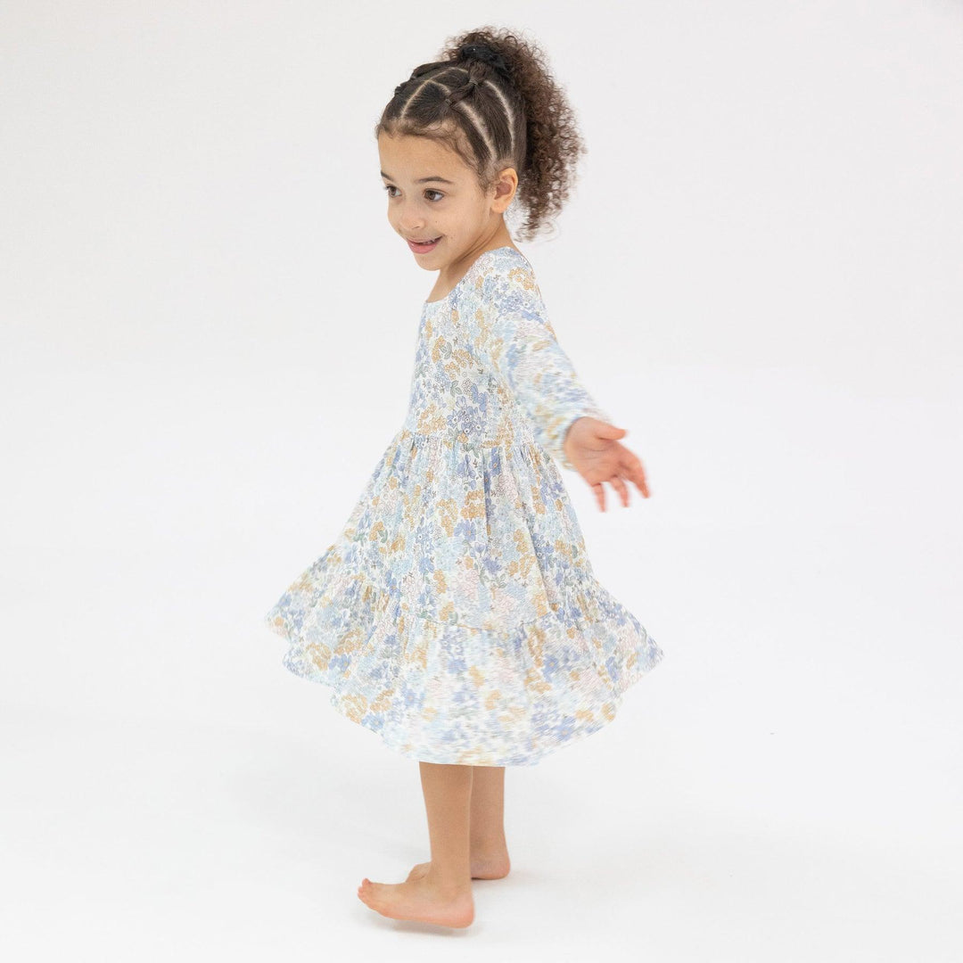 girl twirling in blue floral dress 
