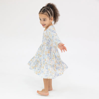 girl twirling in blue floral dress 