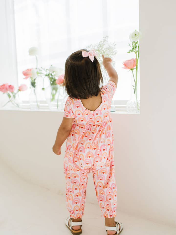 The back of the baby jumpsuit with rainbows and hearts all over print 