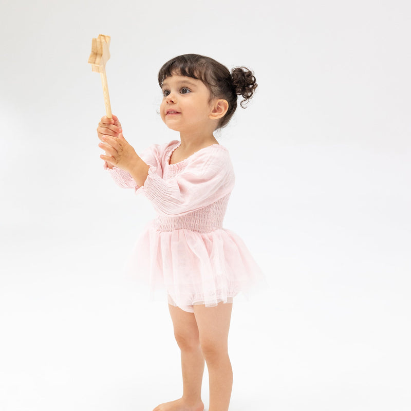 toddler girl modeling the long sleeve tutu bubble in baby pink 