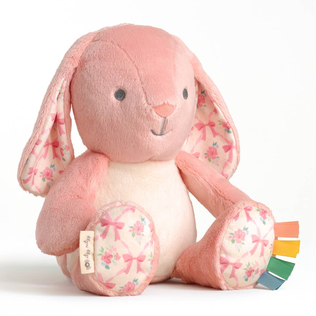 Pink plush bunny toy with floral patterns on a white background
