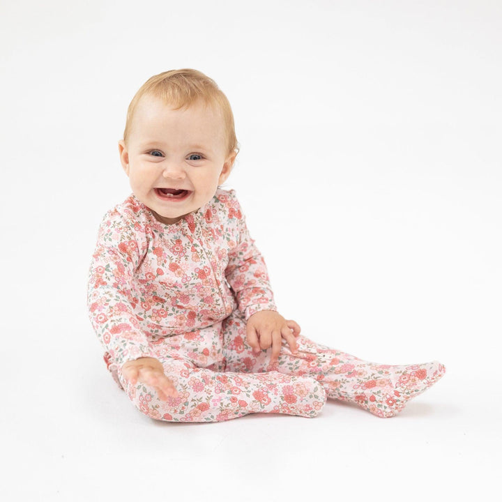 baby modeling a soft footie in a pretty floral design. 