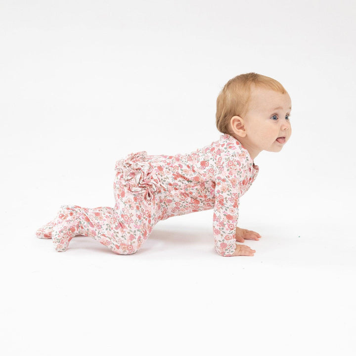 baby crawling in a footie with ruffles on the bum. 