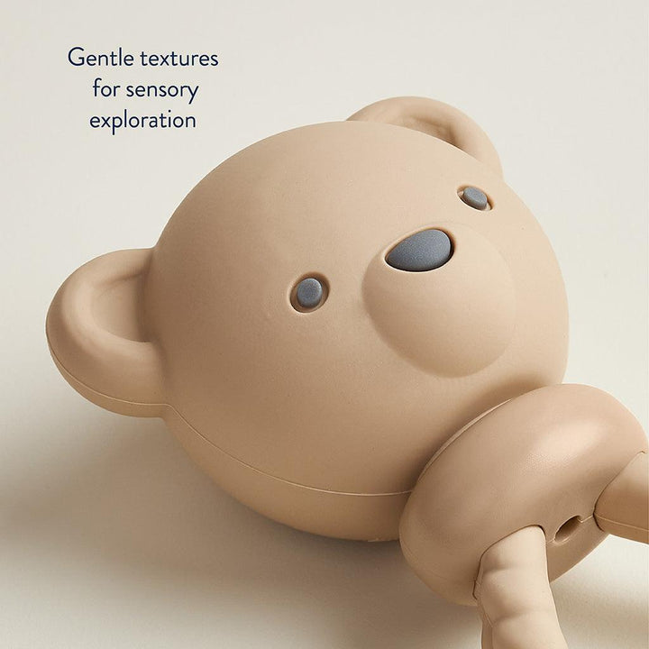 close up image of the teddy bear face on the rattle. 