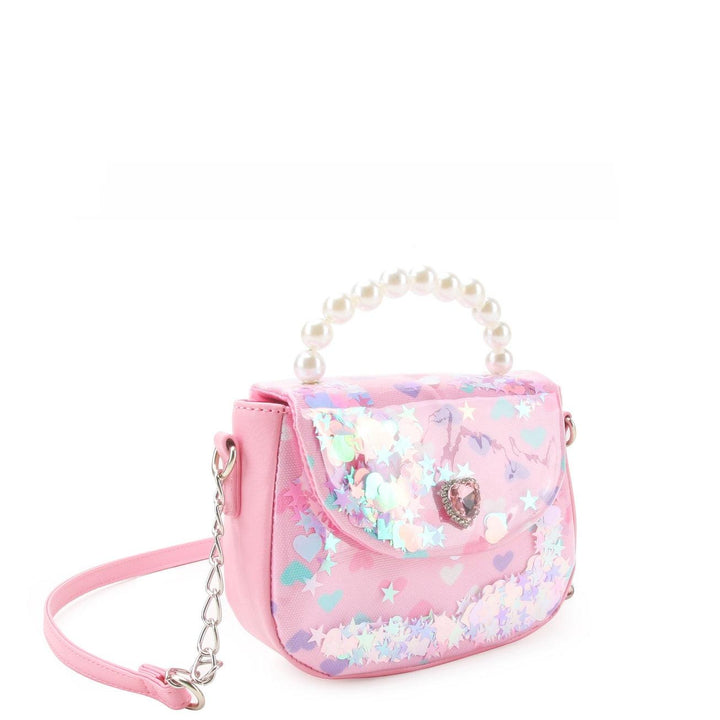 pink crossbody bag with pearl handle and confetti on the inside of the bag. 