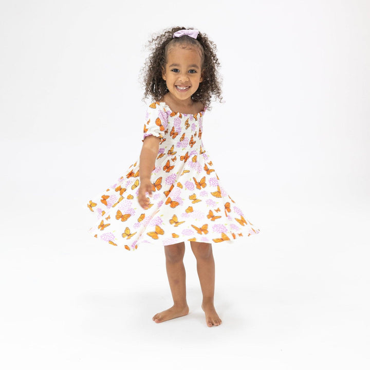 little girl twirling around in the butterfly dress.
