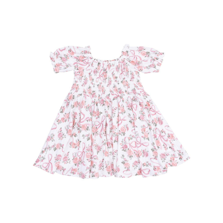 white dress with smocking along the chest and pink ribbons and pink rose bouquets all over the dress. 