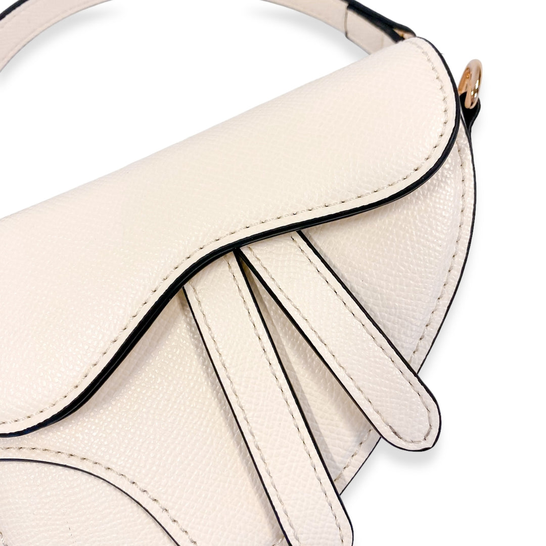Close-up of a beige handbag with a decorative strap on a white background