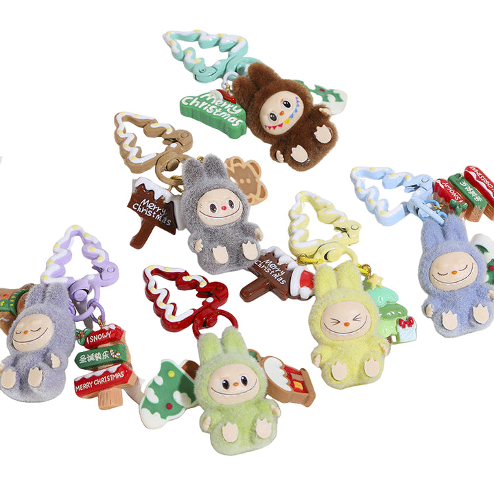 Collection of small plush toys on key chains with Christmas-themed decorations on a white surface.