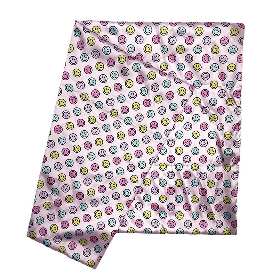 pink satin pillowcase with pink, yellow and blue smiley faces all over it. 