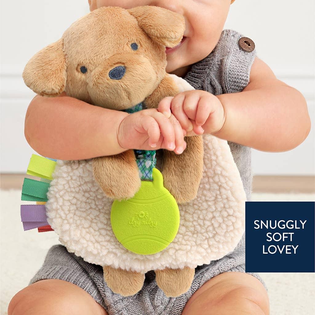 baby hugging the puppy plush with soothing pieces attached. 