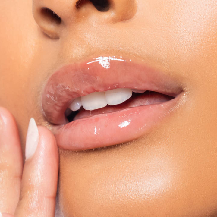 Close-up of a person's lips with a hand gently touching the chin.