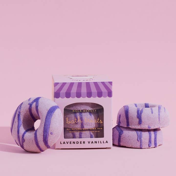 lavendervanilla bath bombs in the shape of doughnuts with icing drizzle. the doughnuts are purple in color and come 3 to a set. 
