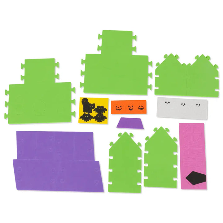 Set of green and purple foam puzzle pieces with Halloween-themed stickers on a white background
