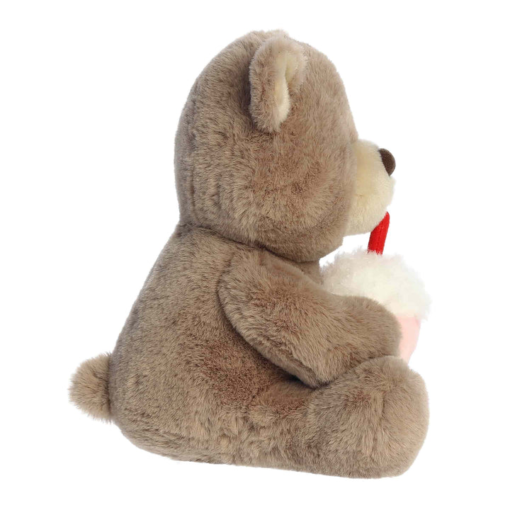 Plush teddy bear holding a red heart on a white background