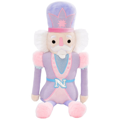 nutcracker plush with pink and purple outfit. this picture has nutcracker sitting down