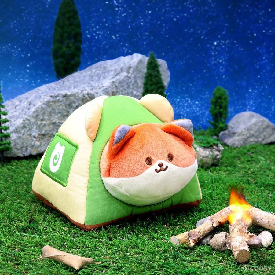 stuffed animal fox laying in a plush tent. 