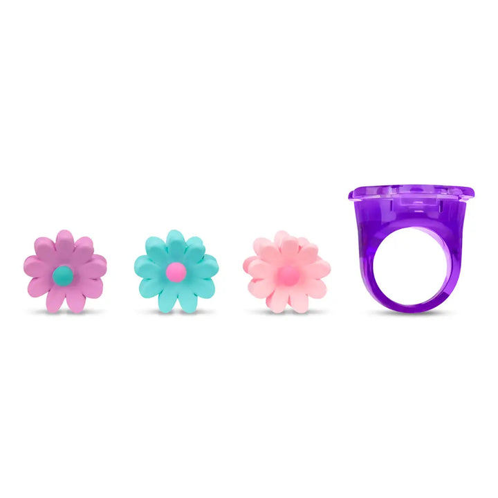 Set of three colorful flower-shaped objects and a purple ring on a white background