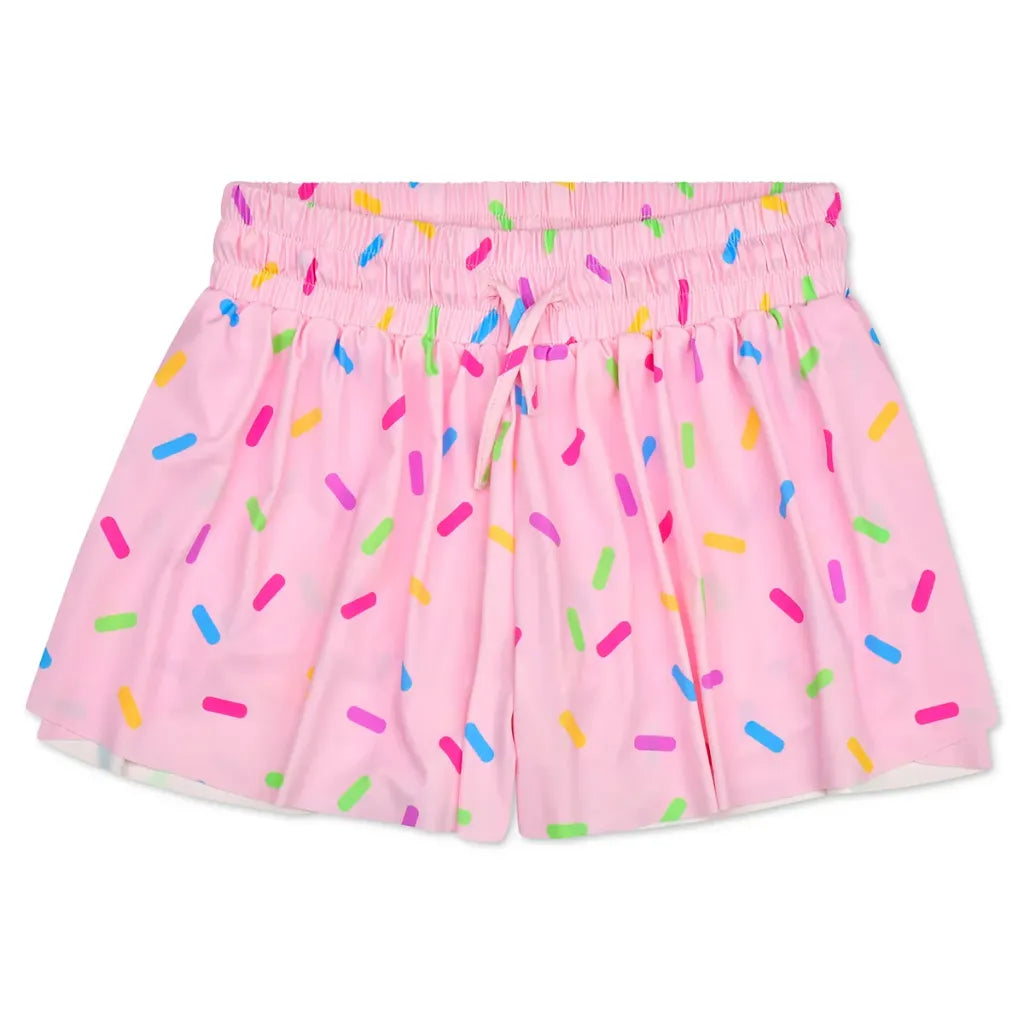 Pink shorts with a colorful sprinkle pattern, featuring an elastic waistband and drawstring.