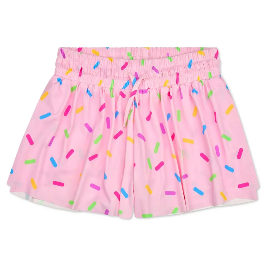 Pink shorts with a colorful sprinkle pattern, featuring an elastic waistband and drawstring.