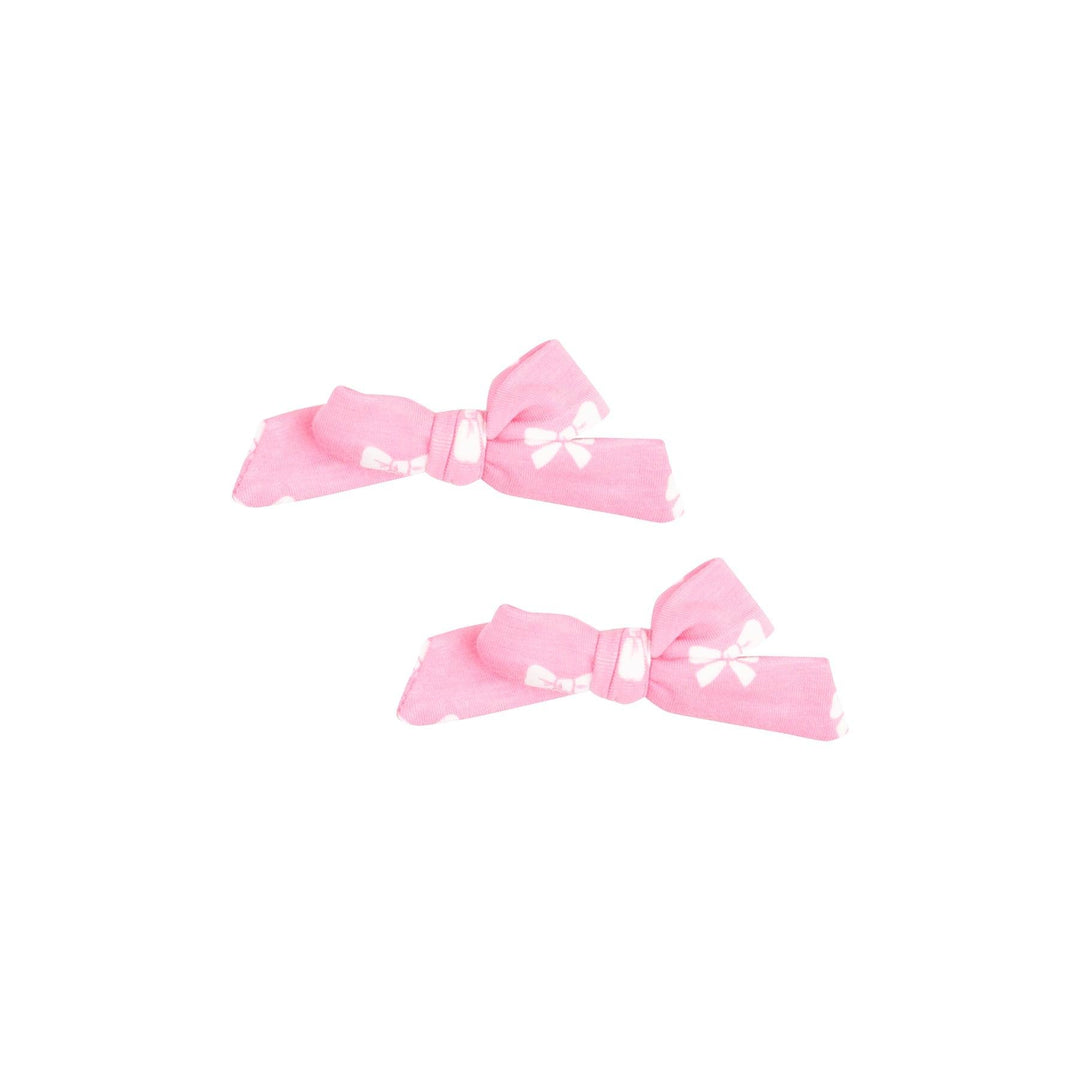 set of 2 hair bows attached to a clip. pink bow with white bows printed on the fabric. 