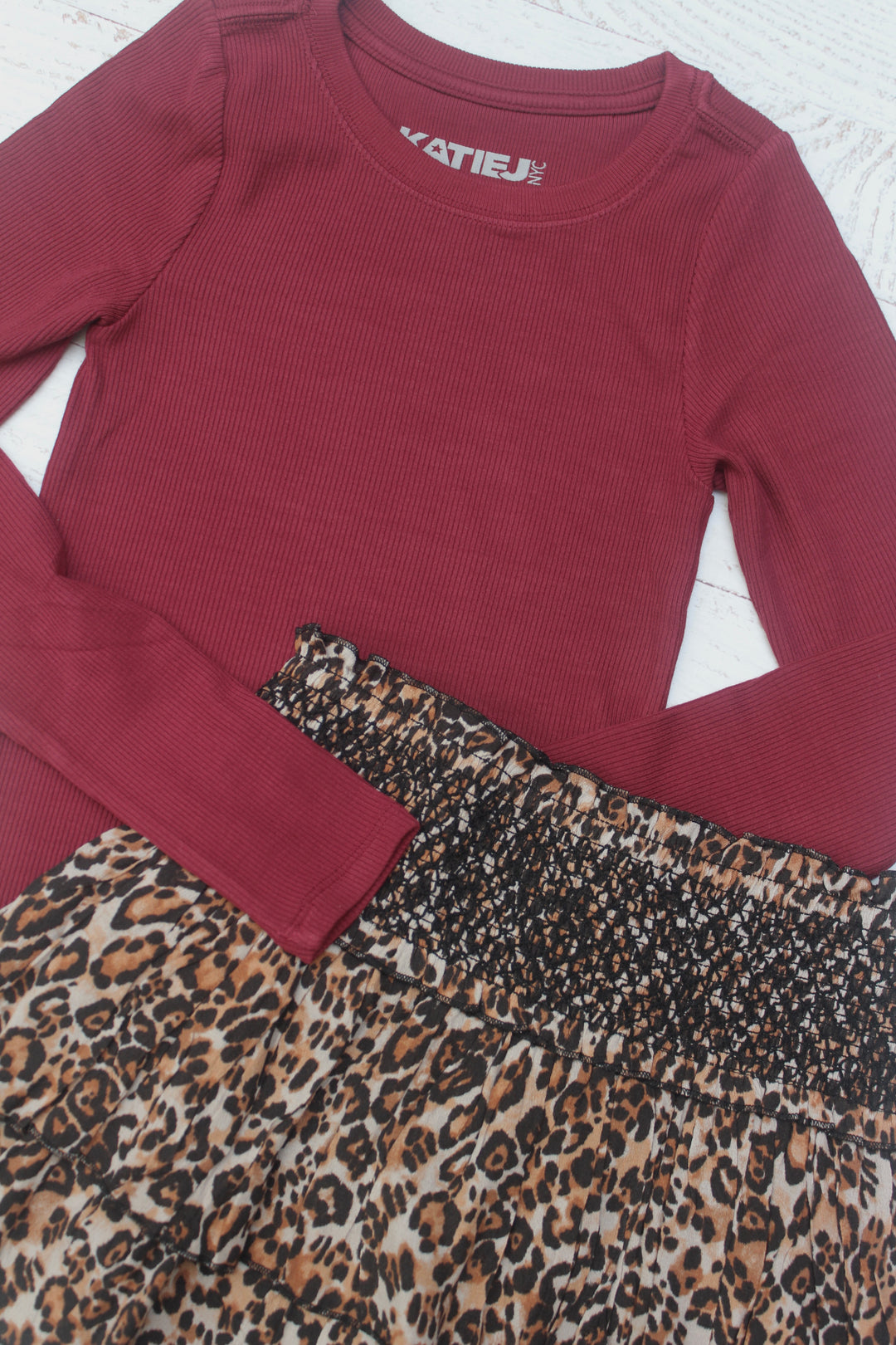 Maroon long-sleeve top with leopard print trim on a white background