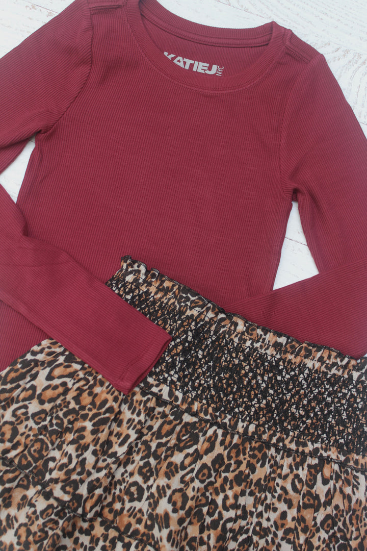 Maroon long-sleeve top with leopard print trim on a white background