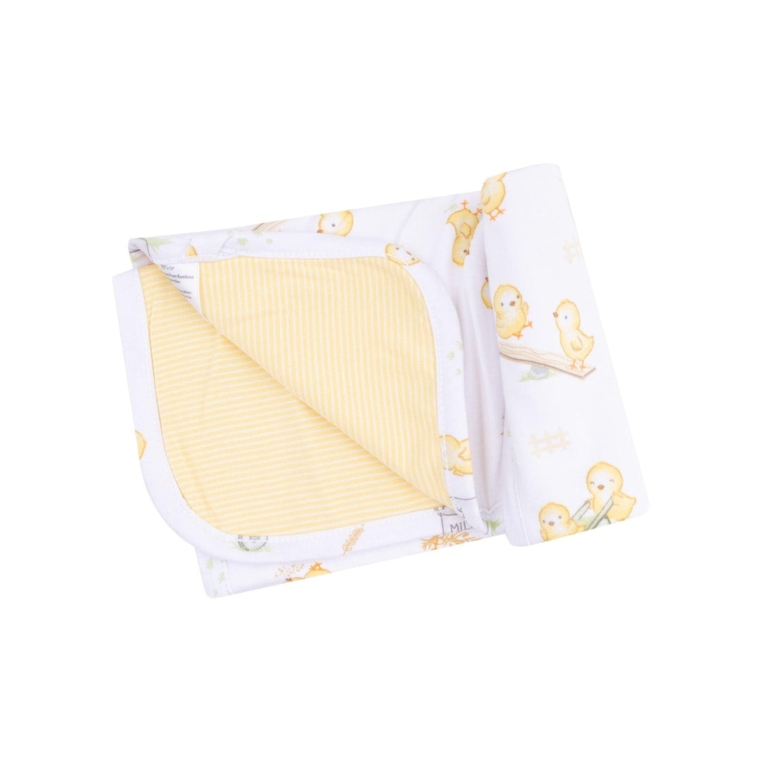 baby blanket made of bamboo with yellow stripes on one side and baby yellow chicks on the other side. 