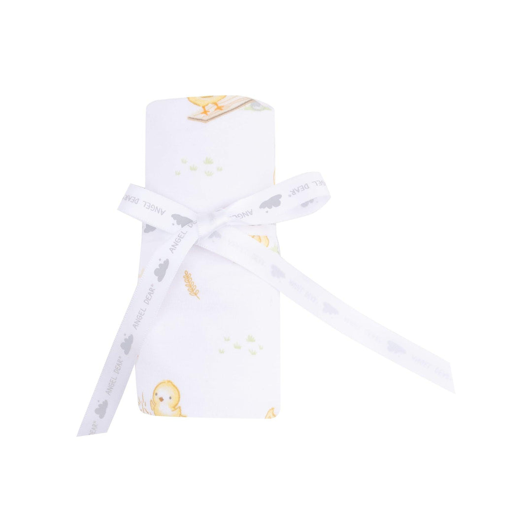 baby blanket rolled and tied with a ribbon , the way it would be sold to a customer. 