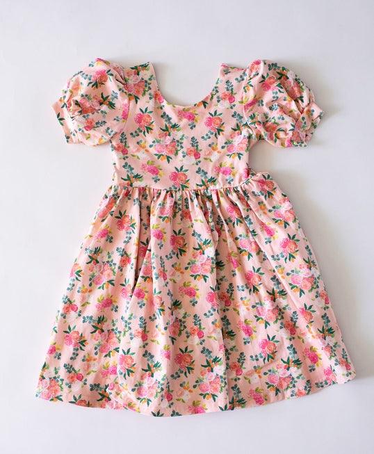 peach dress with puff sleeves and pink cabbage roses all over the dress. 