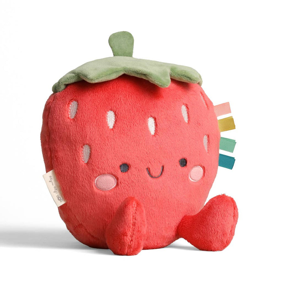 Plush strawberry toy with a smiling face on a white background