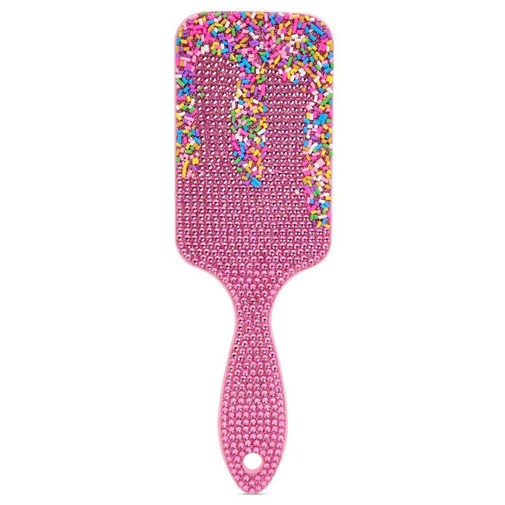 pink sparkly hair brush with sprinkles and gems on it. 