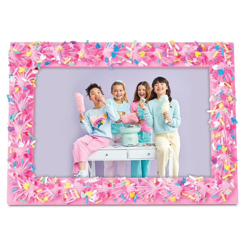 picture frame outlined in pink frosting with rainbow sprinkles on top of the frosting. 