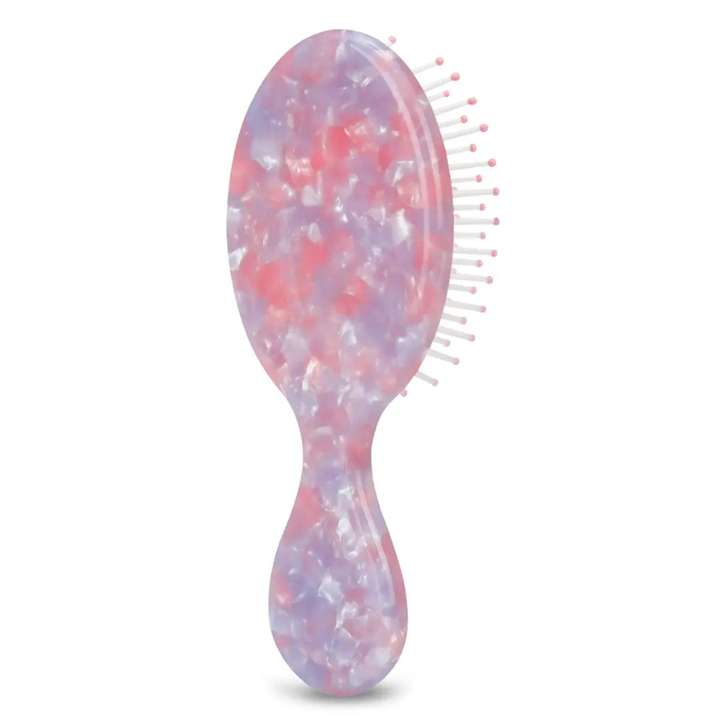 Hairbrush with a pink and purple glittery handle on a white background