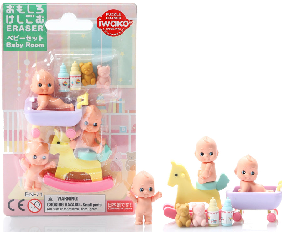 Packaged set of miniature baby figures with accessories, including a crib and toys, on a white background.