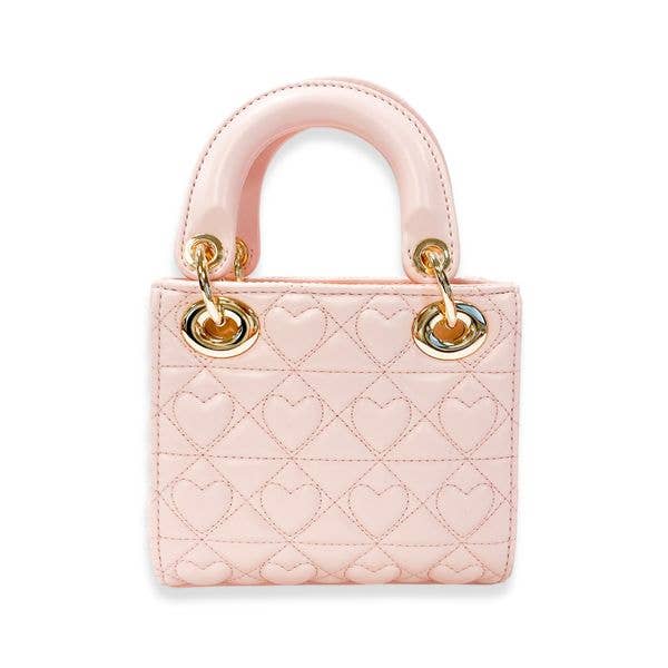 Pink quilted handbag with gold hardware on a white background