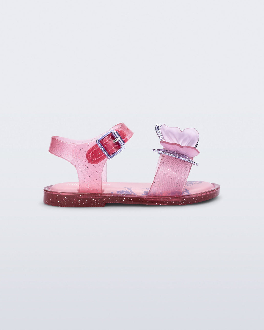 Pink children's sandals with a clear strap on a light gray background