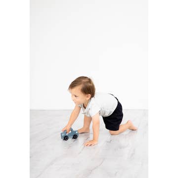 small child playing with the car and moving it along the floor