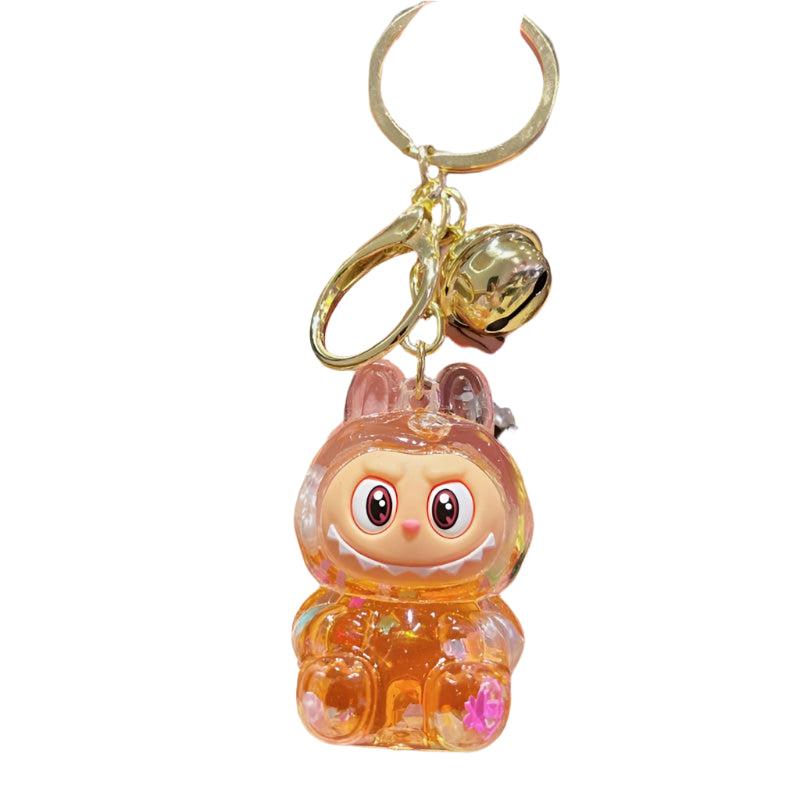 Labubu inspired keychain in clear acrylic case with orange glitter and confetti attached to a gold keyring. 