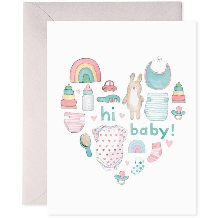 watercolor design with baby designs in the shape of a heart: baby bottle, rainbow, diapers, bibs, baby onesie and building blocks. this card is for a boy or girl. 
