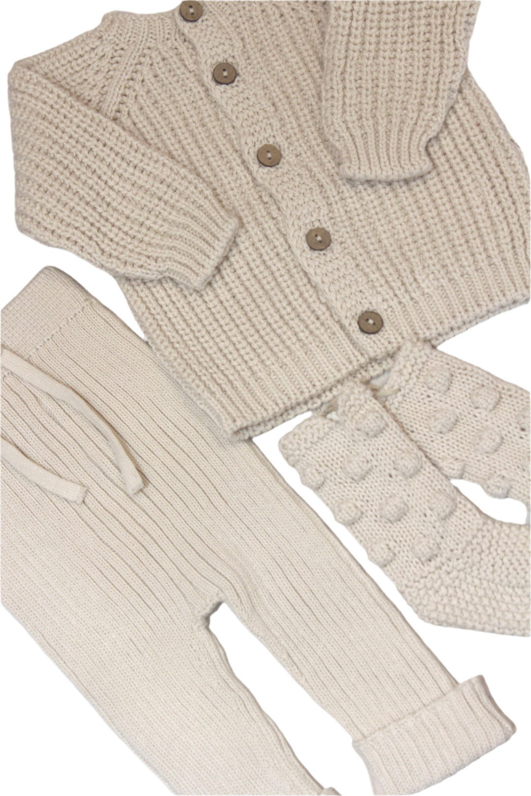 knit baby items in creme color: cardigan sweater, knit pants, and baby booties. 