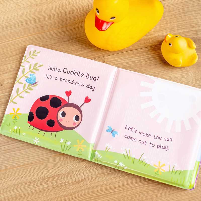 Children's book with a ladybug illustration on a wooden surface with rubber ducks.