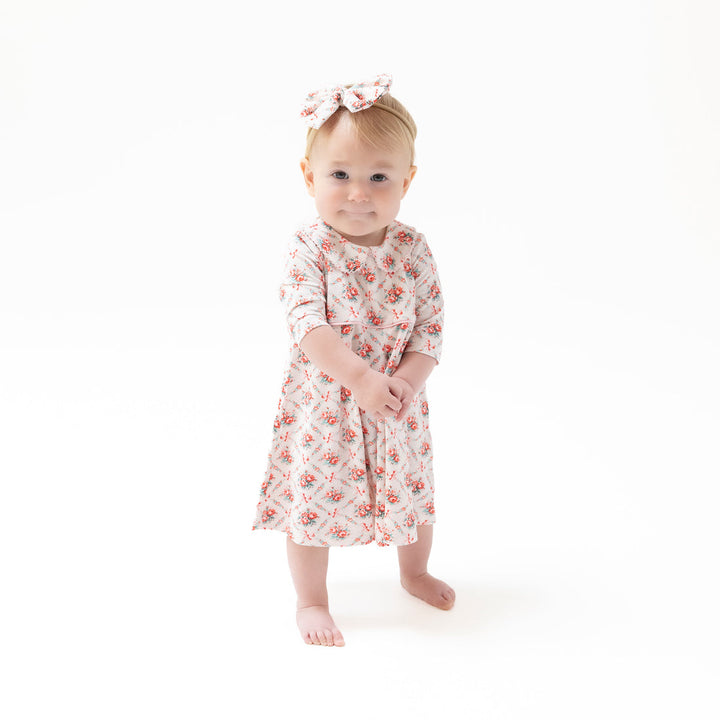 Baby wearing a floral dress on a white background