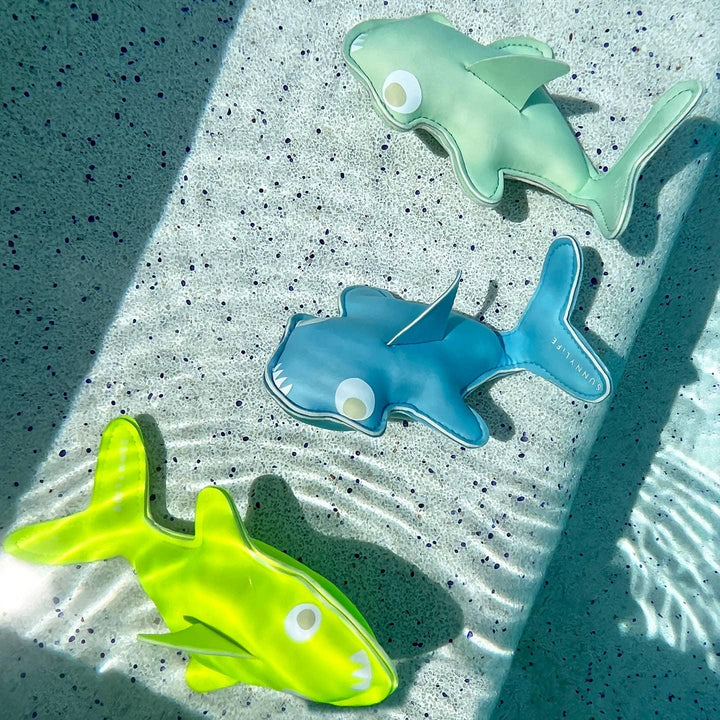 3 sharks in the water: neon yellow, blue and green: all shown in the water. 