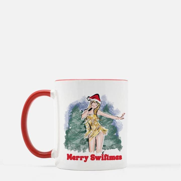 ceramic mug with Taylor Swfift on the front doing a dance in a Christmas outfit. it says 'Merry Swiftmas'